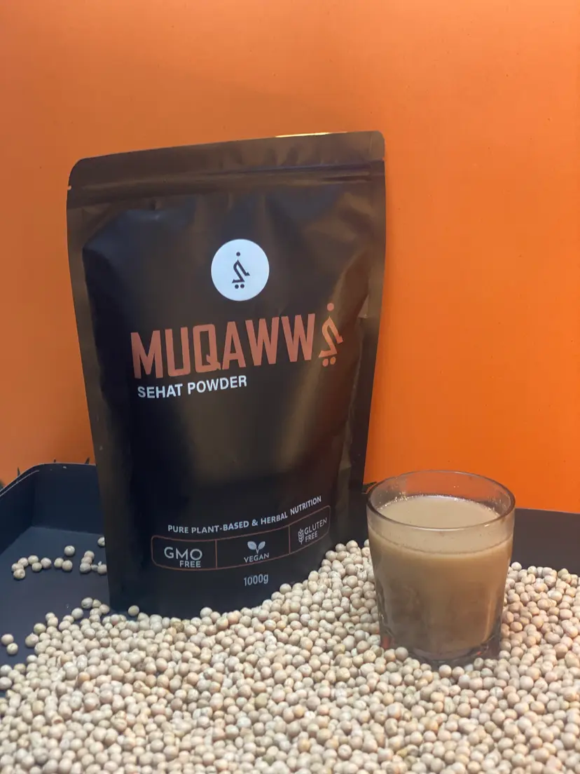 A glass of Muqawwi mixed in milk beside the pouch